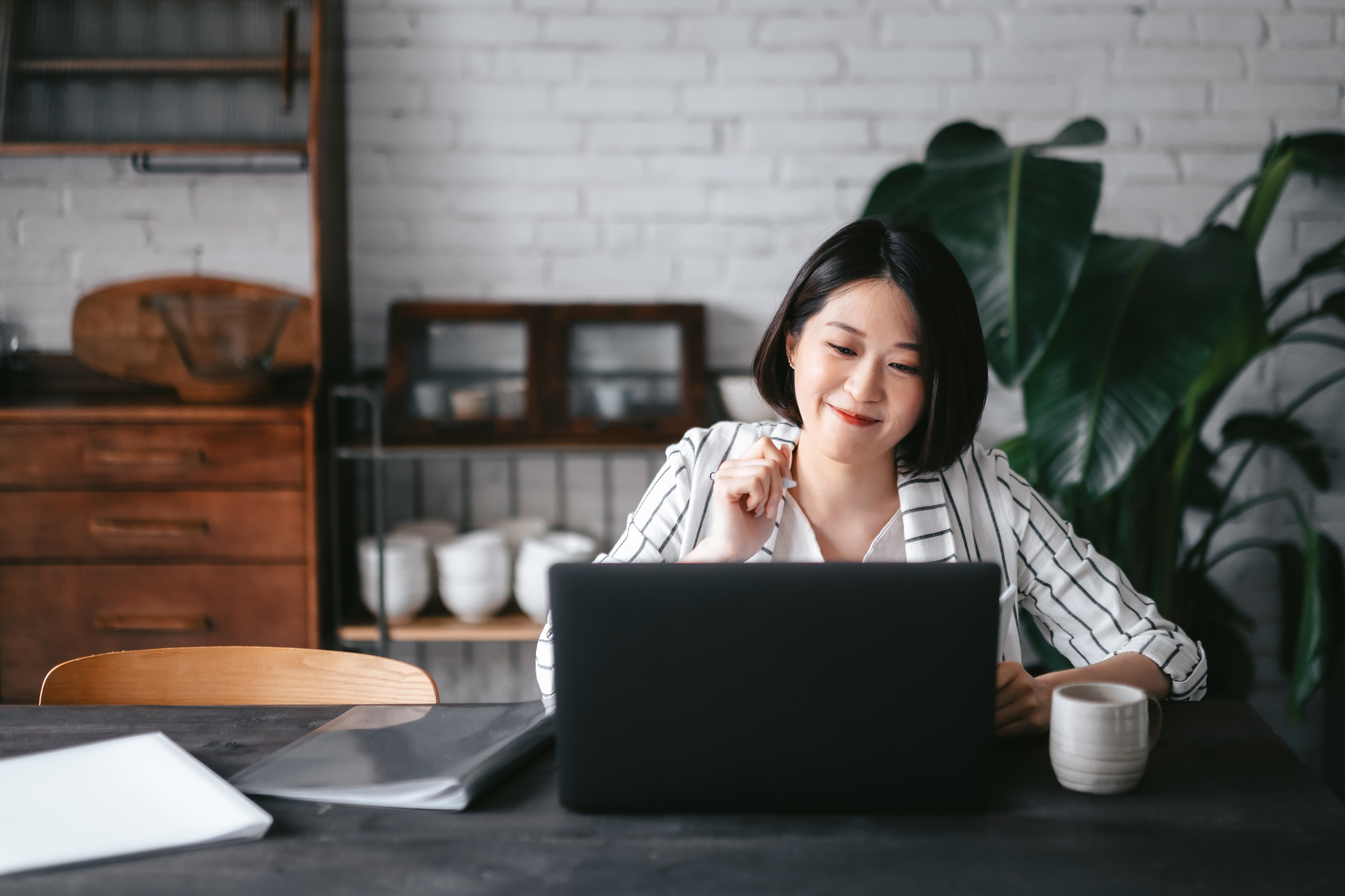 Woman sitting in an office in front of a laptop, smiling
